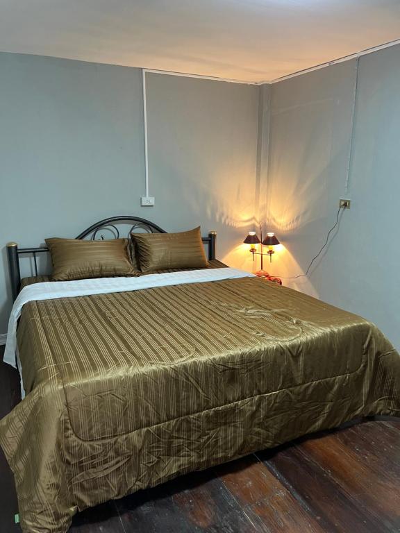 a bedroom with a large bed with a lamp on it at Udon House in Udon Thani
