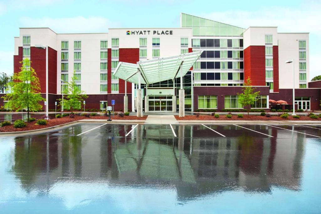 a building with a pool of water in front of it at Hyatt Place Raleigh Cary in Raleigh