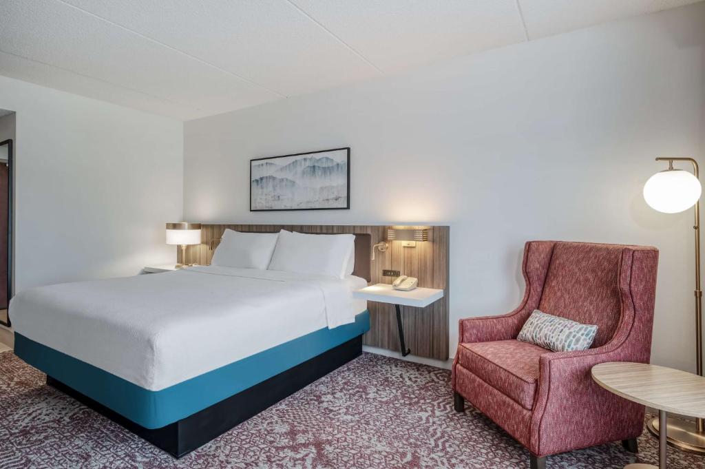 une chambre d'hôtel avec un lit et une chaise dans l'établissement Hilton Garden Inn Clarksburg, à Clarksburg