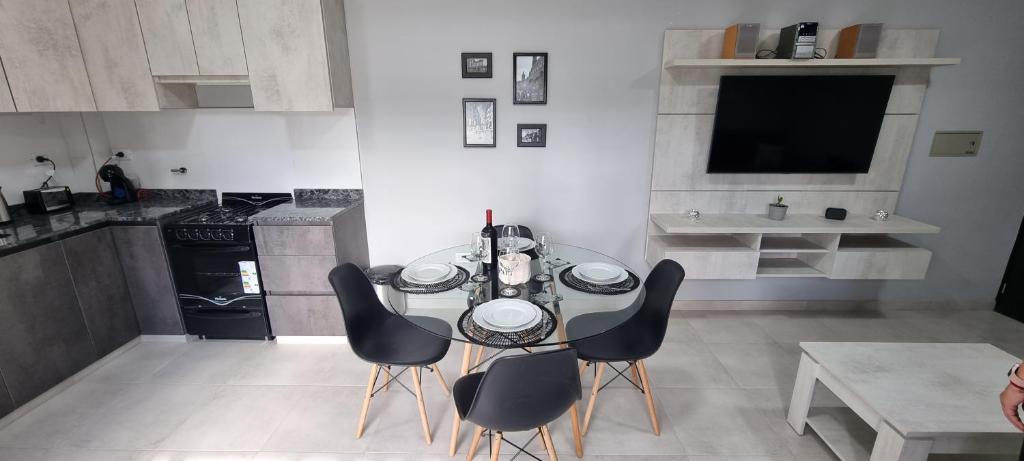 a kitchen with a table and chairs and a television at Departamento en Mendoza - Le Chat Noir in Godoy Cruz