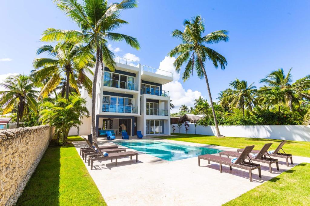 a villa with a swimming pool and palm trees at Villa Blue Amber Cabarete in Cabarete