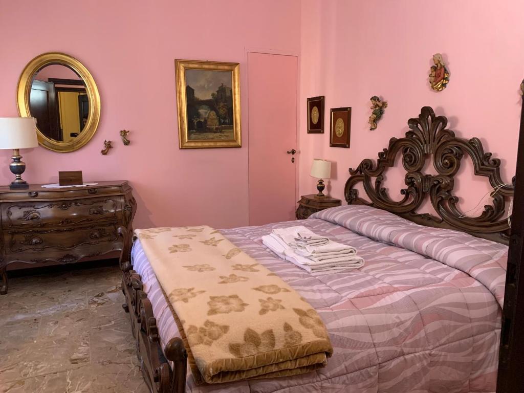 La casa dei sapori a Mirandola في ميراندولا: غرفة نوم بسرير وخزانة ومرآة