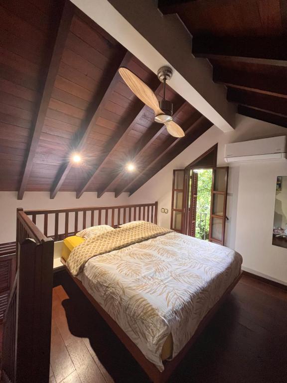 a bedroom with a bed and a ceiling fan at Tikis Mikis in Les Anses-dʼArlets