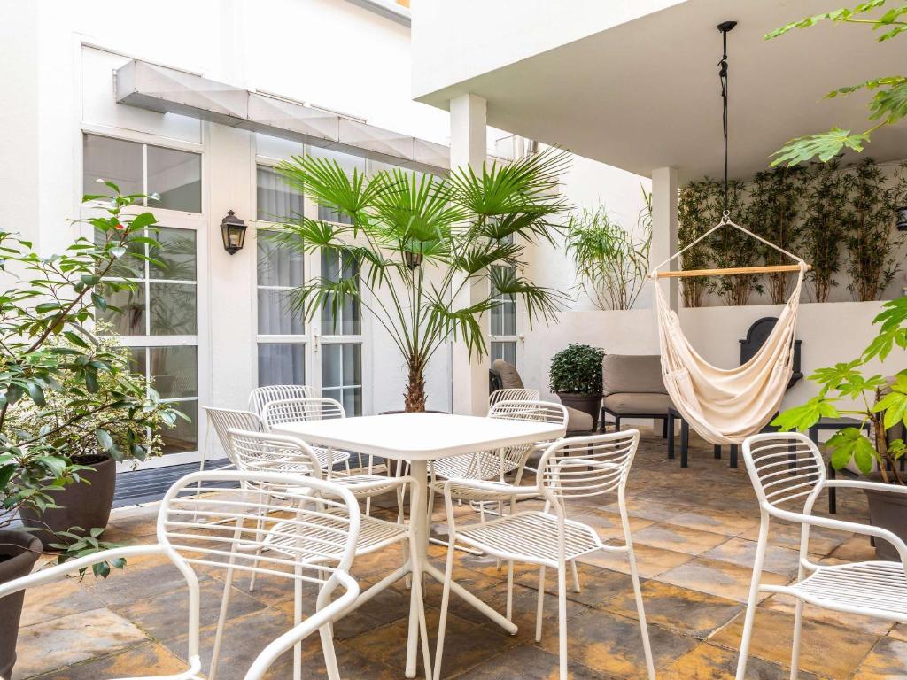 a patio with a table and chairs and a hammock at ibis Paris Ornano Montmartre Nord 18ème in Paris