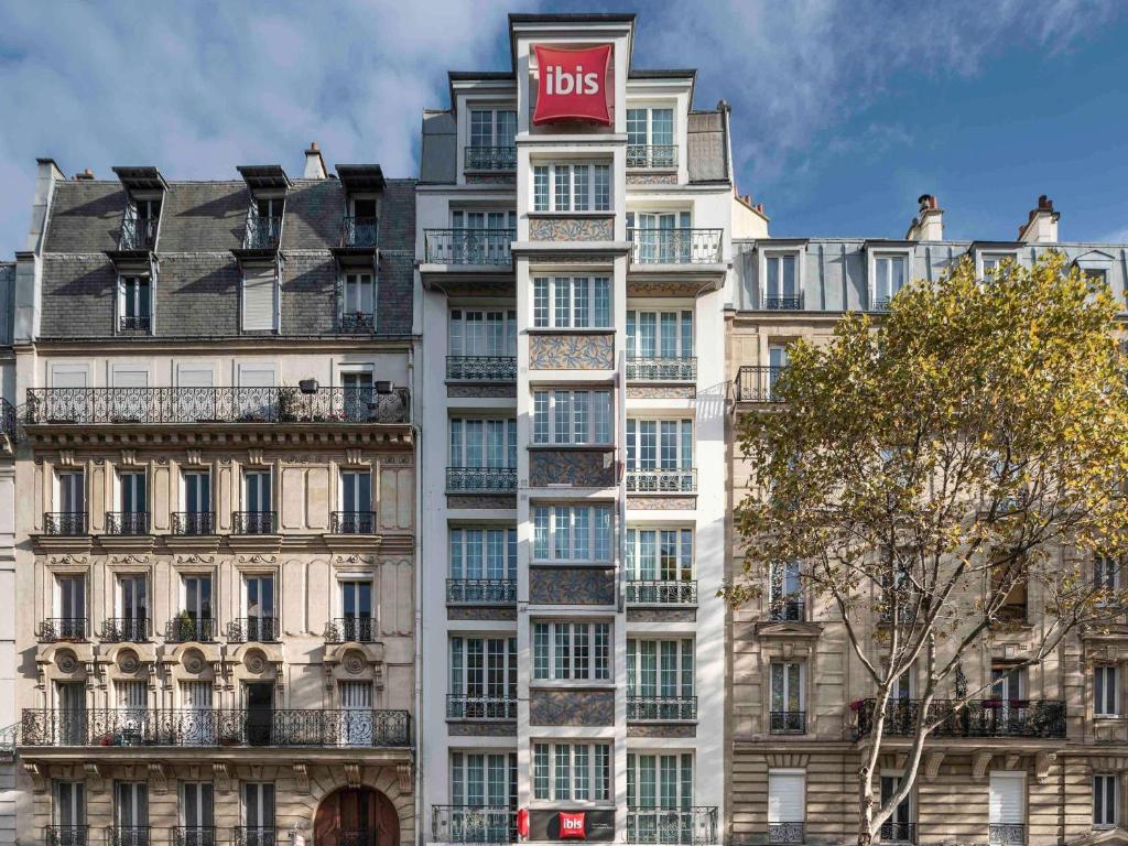 a tall building with a bus sign on top of it at ibis Paris Ornano Montmartre Nord 18ème in Paris