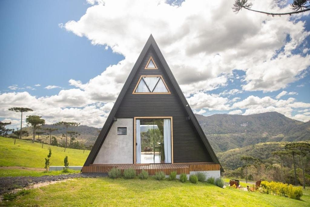 a church with a triangular roof on a green field at A Cabana mais aconchegante da Serra Catarinense in Urubici