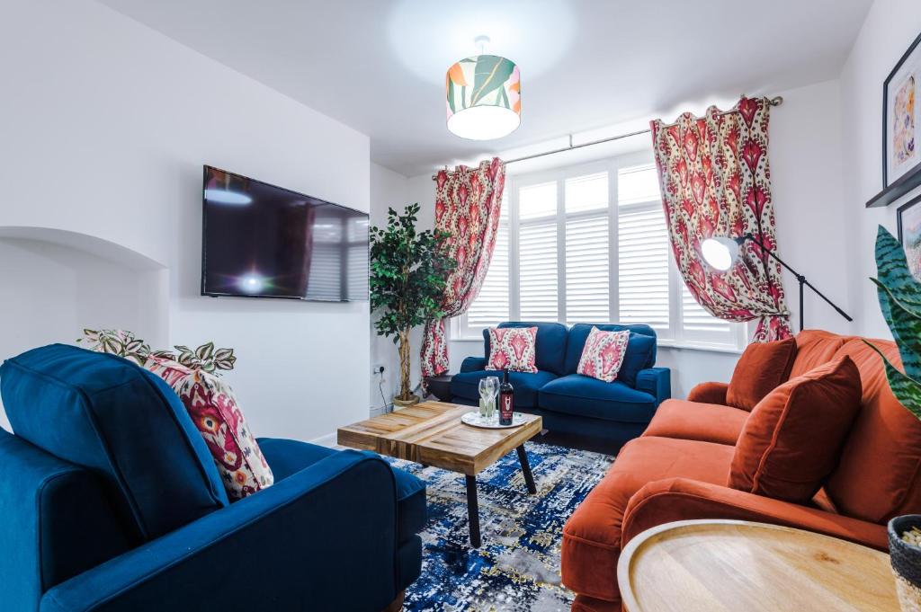 a living room with blue couches and a table at 3Bed Luxury Retreat - Your Perfect Coventry Holiday Home Away in Coventry