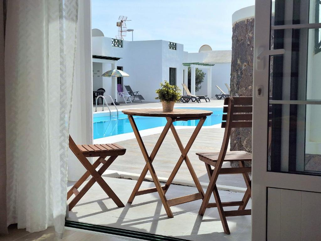 a table and chairs on a balcony with a pool at Casa Limoncello in Puerto del Carmen