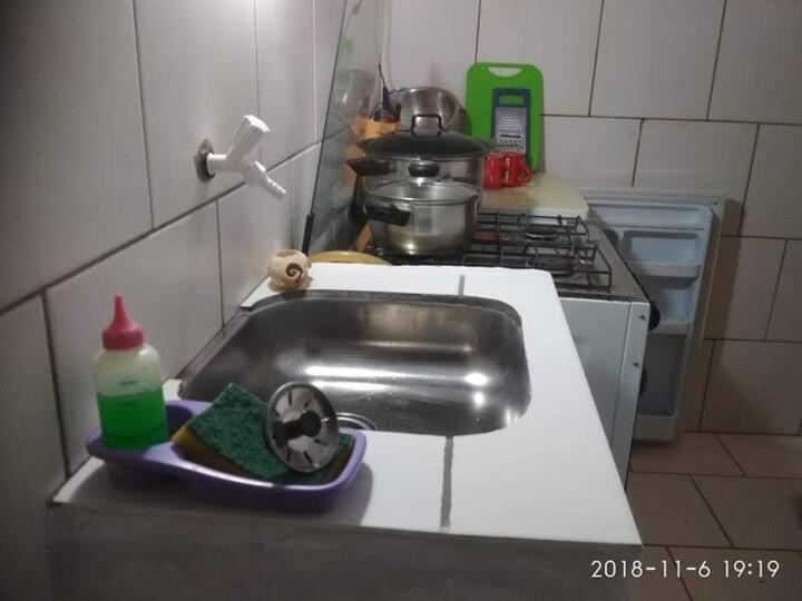 a kitchen counter with a sink and a stove at la cueva del diablo in Punta Del Diablo