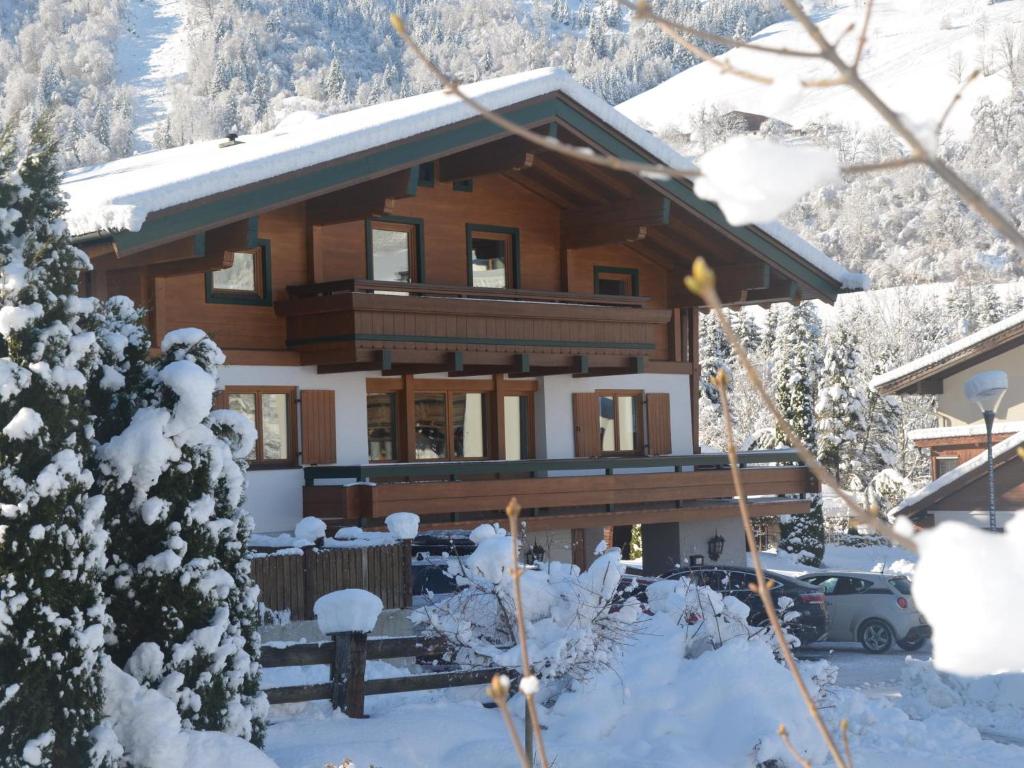 a large wooden house with snow on the ground at Familienchalet Kitzblick in Kaprun