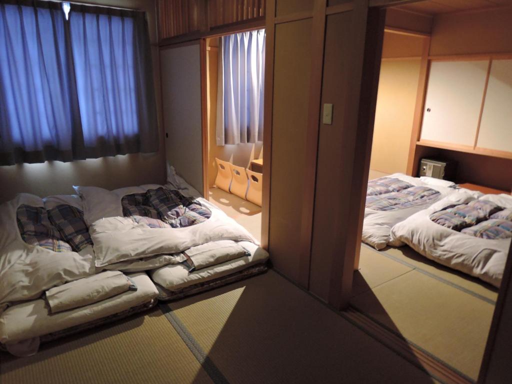 Postel nebo postele na pokoji v ubytování Maruni Ryokan