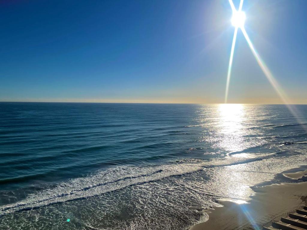 um sol a brilhar sobre o oceano numa praia em Arenales del sol, primera linea de playa em Arenales del Sol