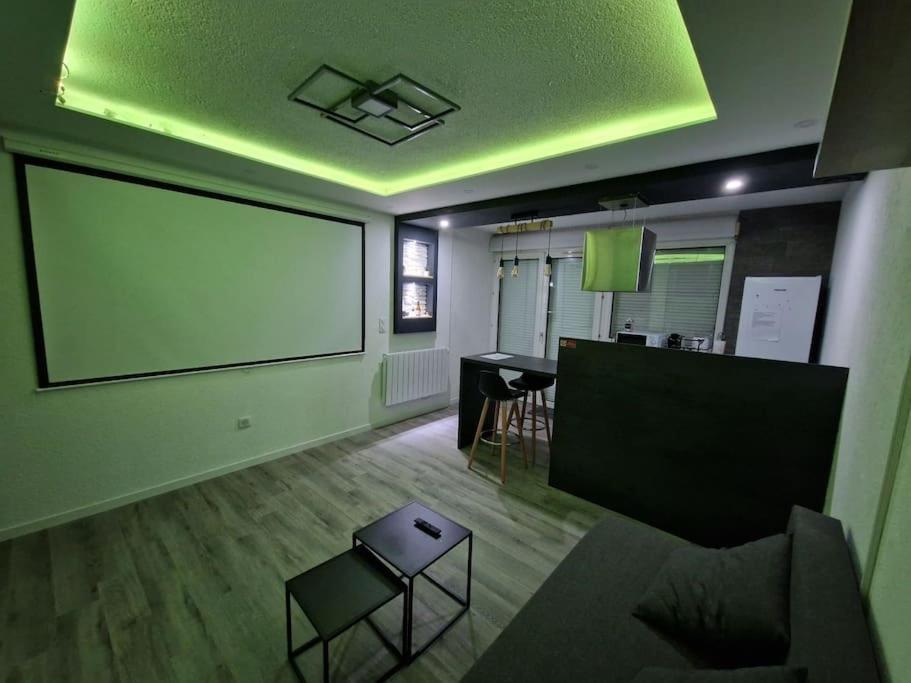 a living room with a large screen on the wall at Logement Atypique in Gex