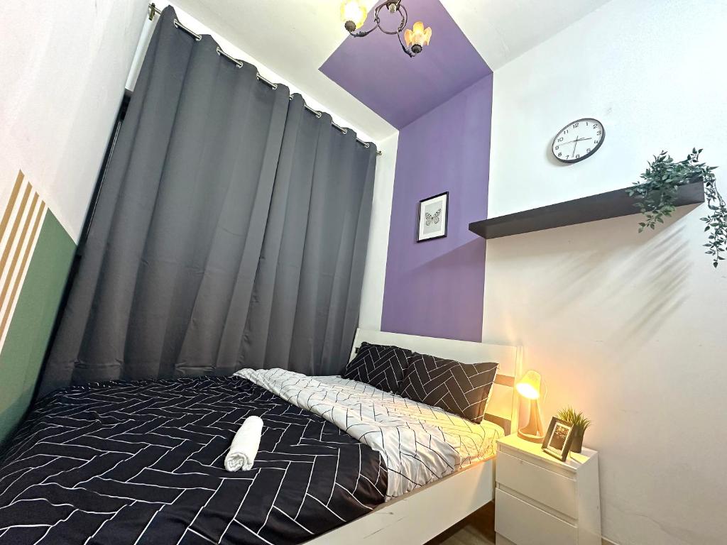 a bedroom with a bed with a purple accent wall at Beautiful Double Partition Room in Tecom Near ICM Metro in Dubai