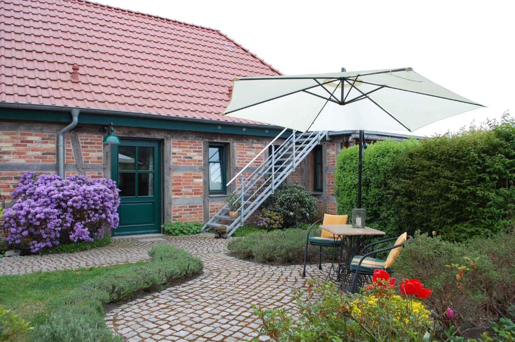 eine Terrasse mit einem Tisch, einem Sonnenschirm und einer Leiter in der Unterkunft Apartment in Sehlen/Insel Rügen 3075 in Sehlen