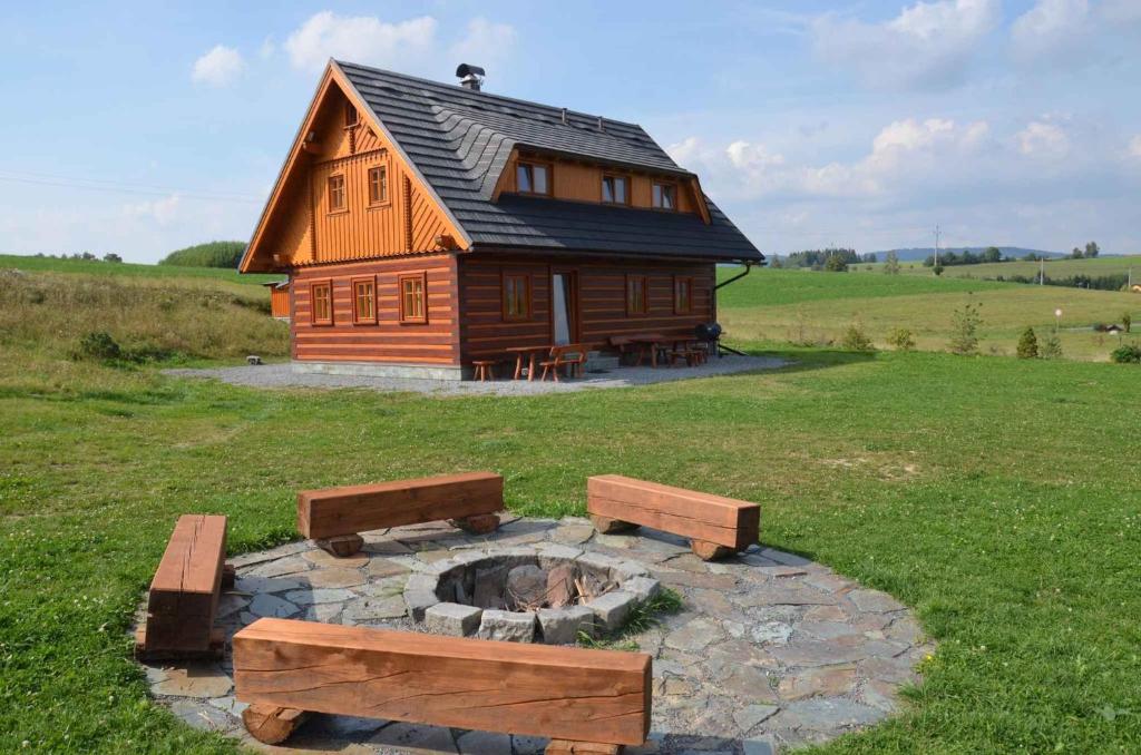 een blokhut met een vuurplaats ervoor bij Holiday home in Jilove u Drzkova 1736 in Jílové u Držkova