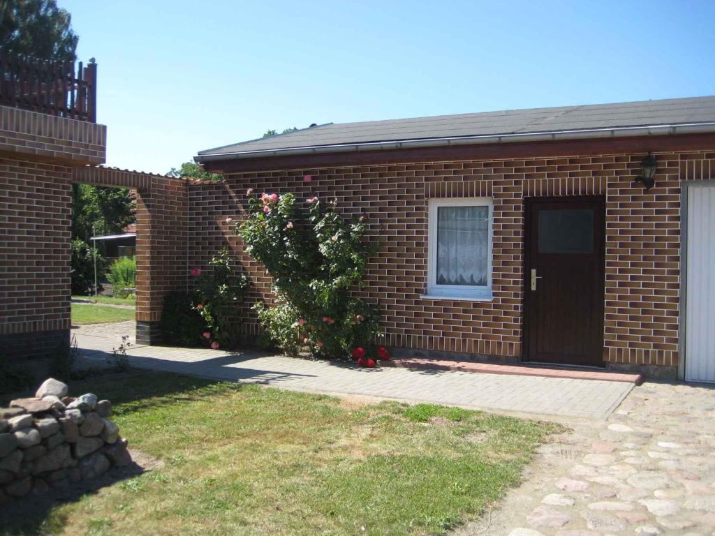 a brick house with a door and a yard at Studio in Usedom - Insel Usedom 2319 in Welzin