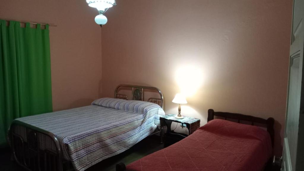 sypialnia z 2 łóżkami i zieloną zasłoną w obiekcie Dani I w mieście Jesús María