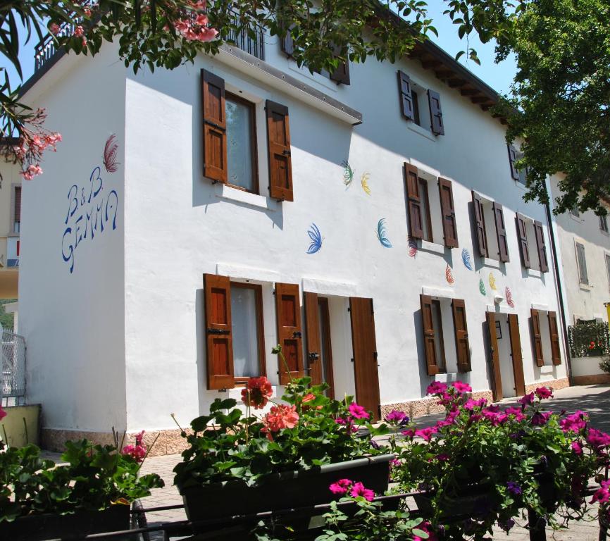 a white building with flowers in front of it at Bed & Breakfast Gemma in Grezzana