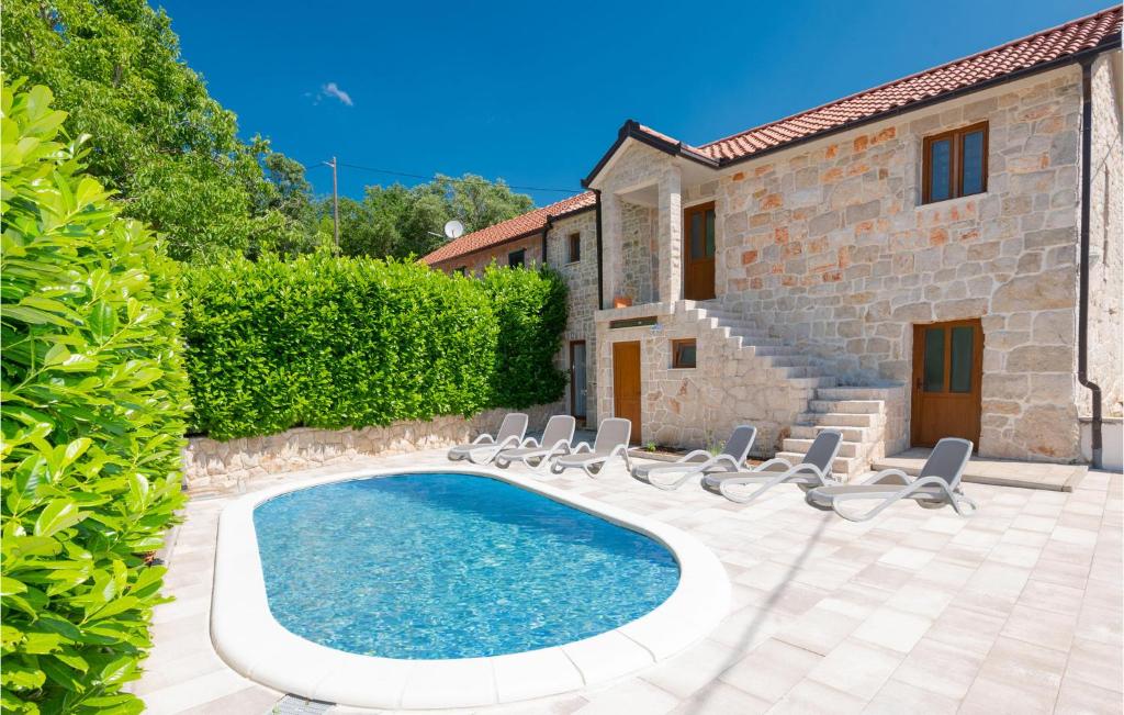 Villa con piscina frente a una casa en 3 Bedroom Nice Home In Zmijavci, en Zmijavci