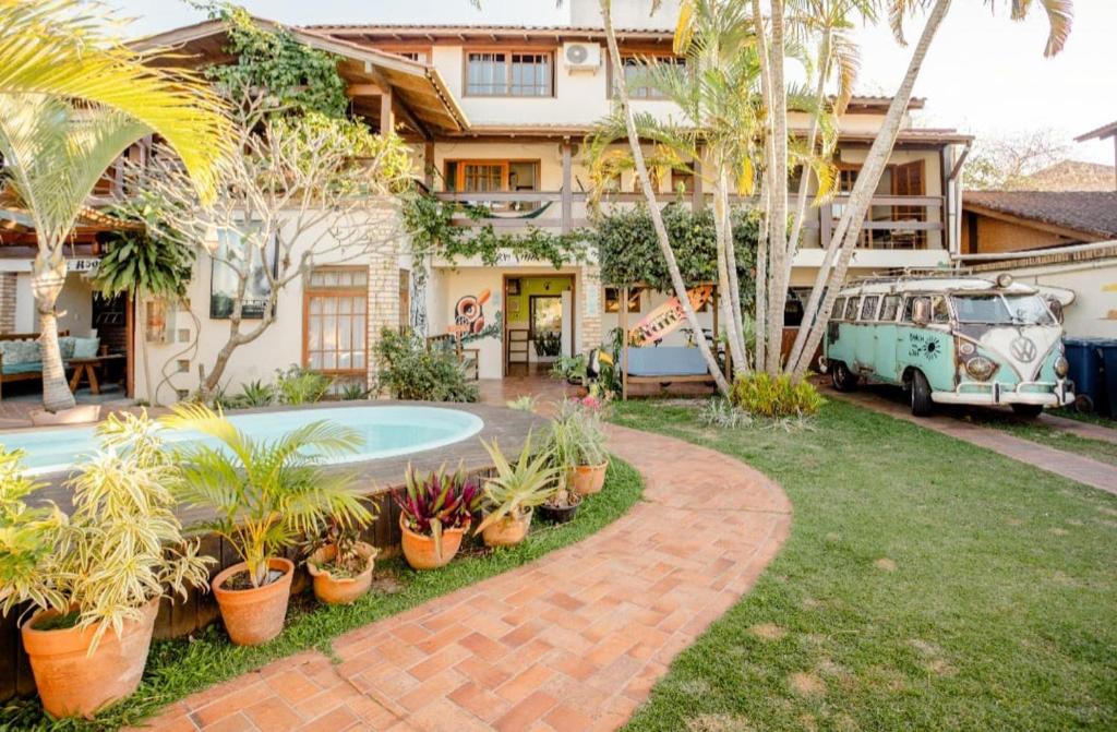 a house with a swimming pool and a yard with plants at Tucano House in Florianópolis