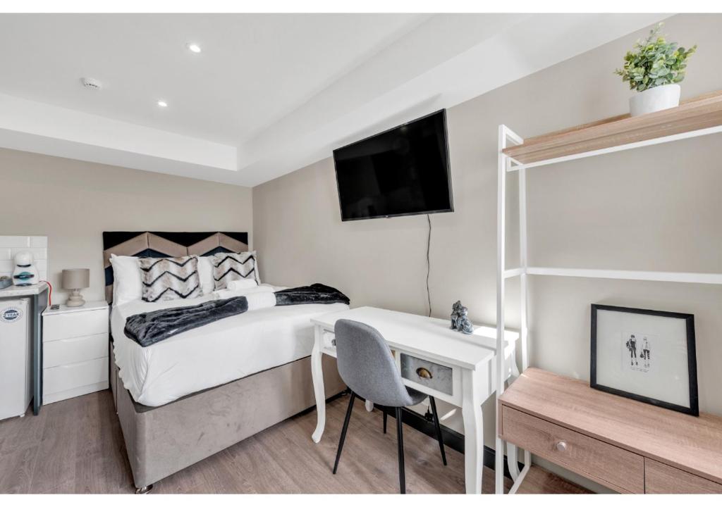 sypialnia z łóżkiem, biurkiem i telewizorem w obiekcie Stay & Explore: Convenient Studio - Prime Location w Londynie