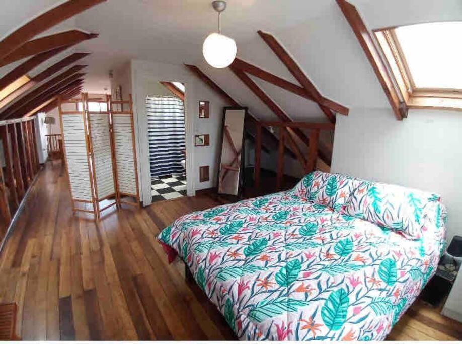 - une chambre avec un lit et du parquet dans l'établissement Loft privado Cerro Alegre, estilo Buhardilla., à Valparaíso