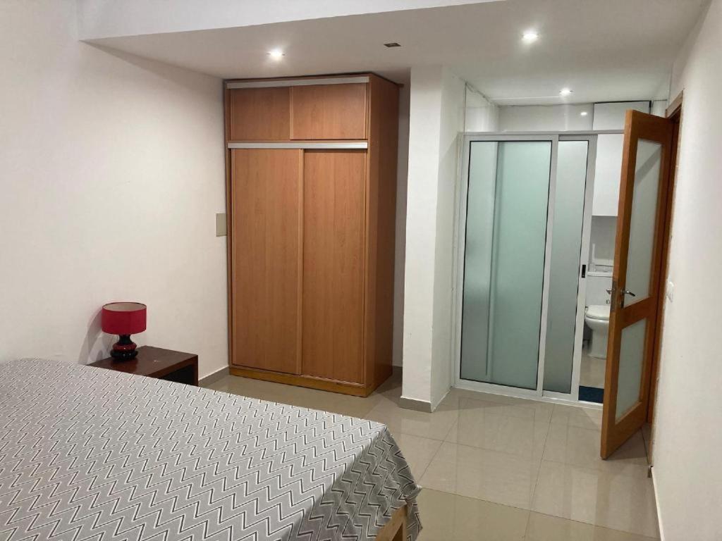 - une chambre avec un lit et une porte coulissante en verre dans l'établissement Alojamento 2Ás, à Praia