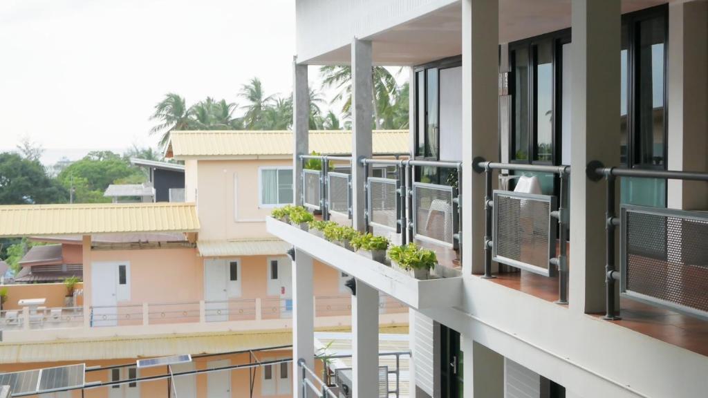 a balcony of a building with windows and plants at Good Dream Hotel (Khun Ying House) in Koh Tao