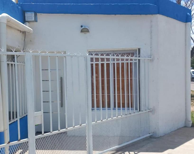 um portão branco em frente a um edifício em Esquina La Argentina em San Luis