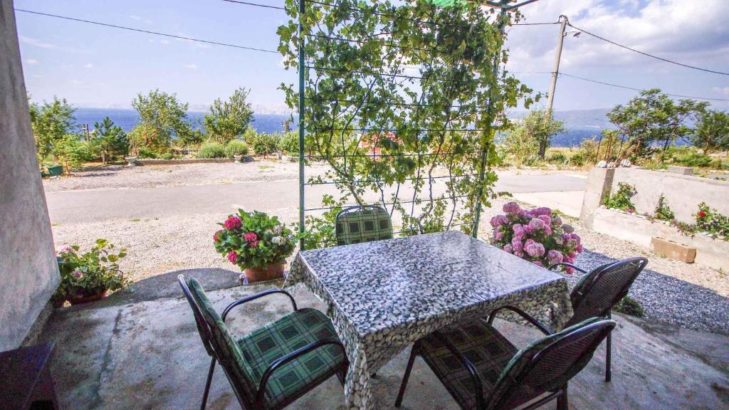 una mesa y sillas en un patio con flores en Holiday home in Senj 17085, en Senj