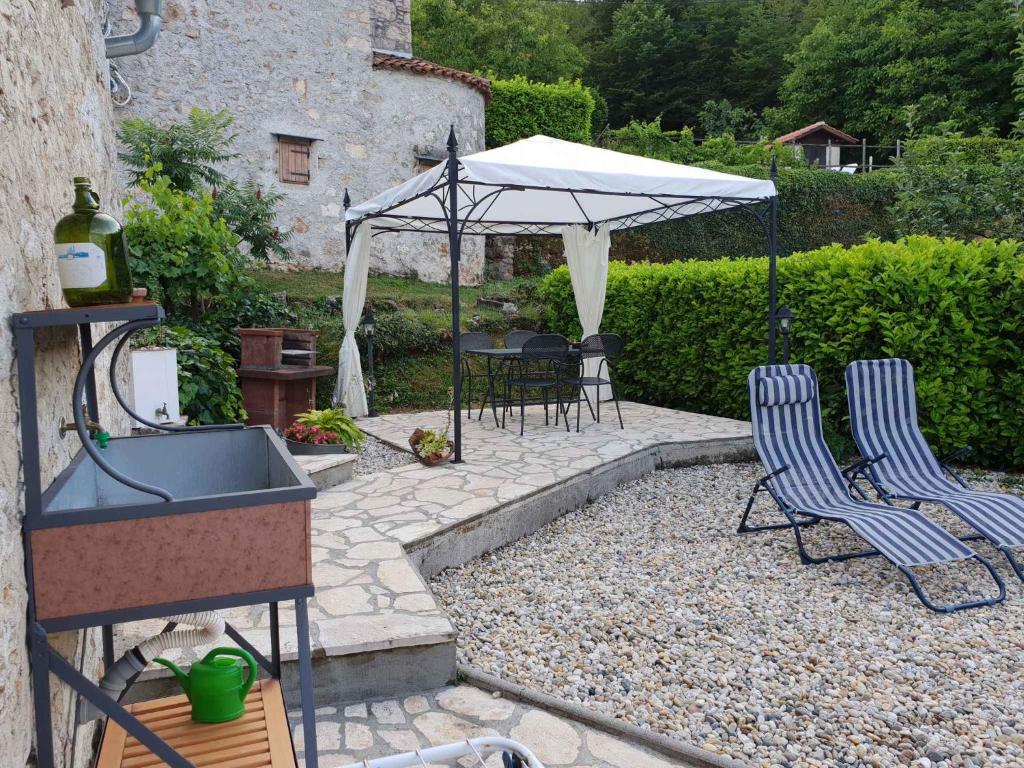 un patio con due sedie, un lavandino e un ombrellone di Holiday home in Dobrec 15115 a Dobreć
