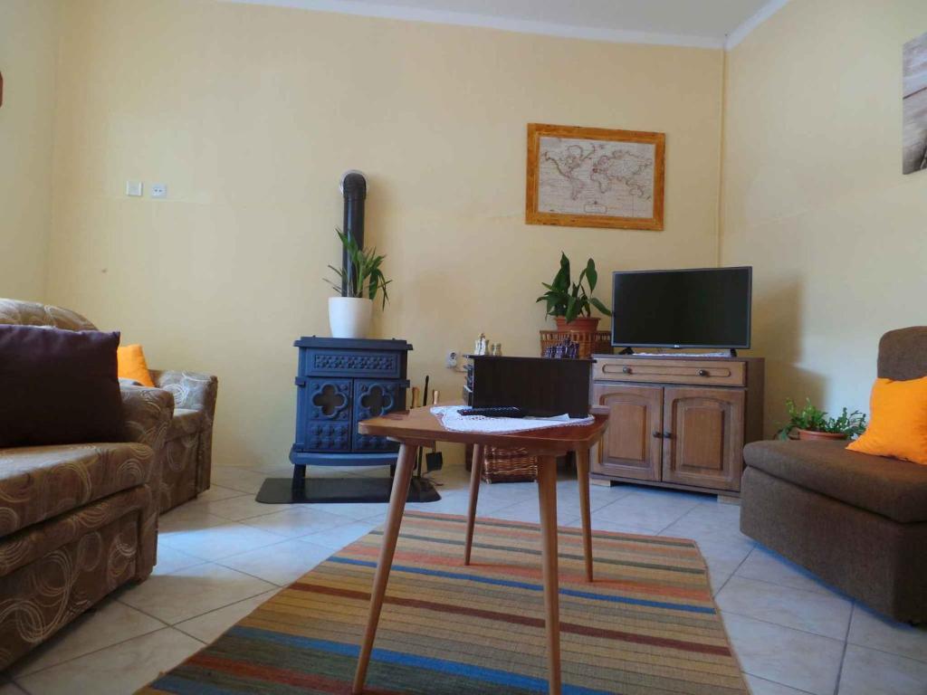 a living room with a couch and a table and a tv at Holiday home in Tribalj 5643 in Tribalj