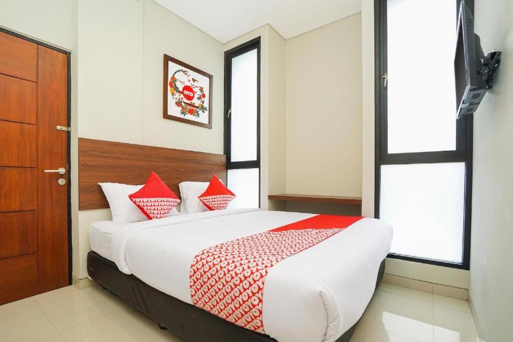 a bedroom with a large bed with red pillows at The Colins Hotel in Surabaya