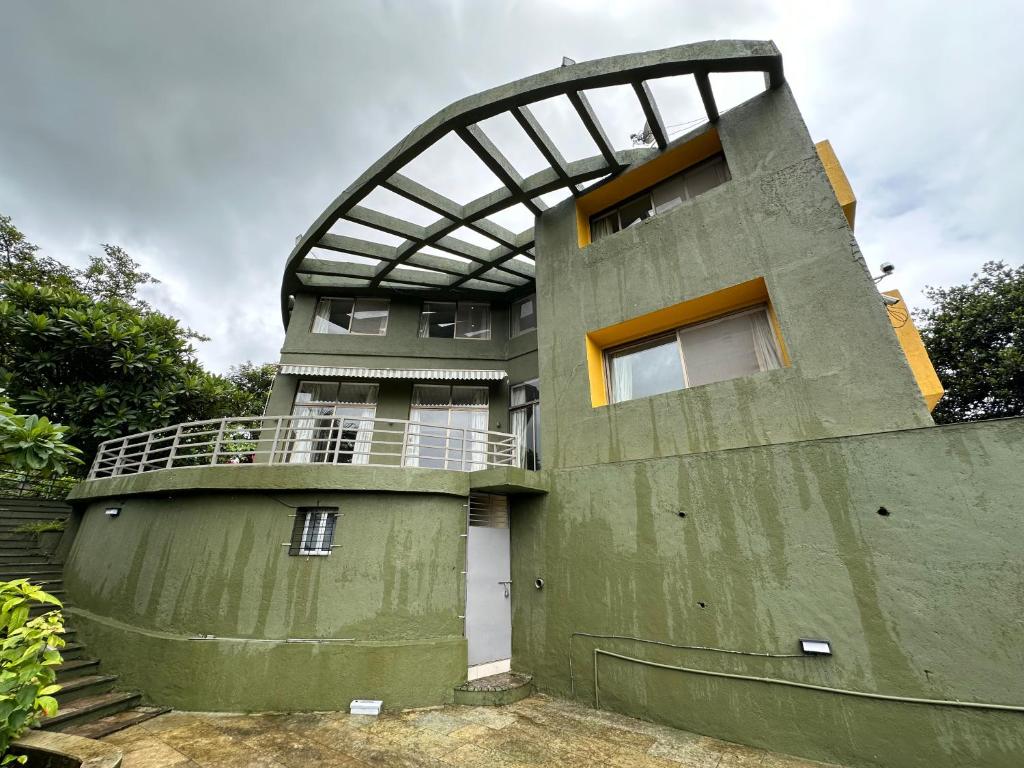a green building with a balcony on top of it at Zio legacy Beautiful 3 BHK Villa in Karjat in Murbād