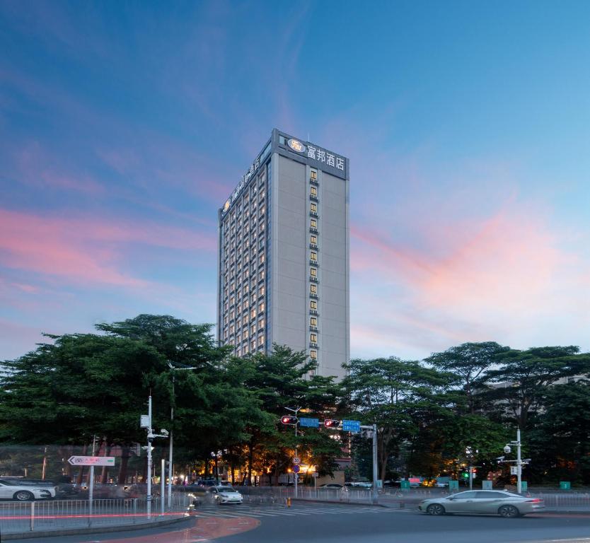 een hoog gebouw met auto's ervoor bij Fortune Land Shenzhen in Shenzhen