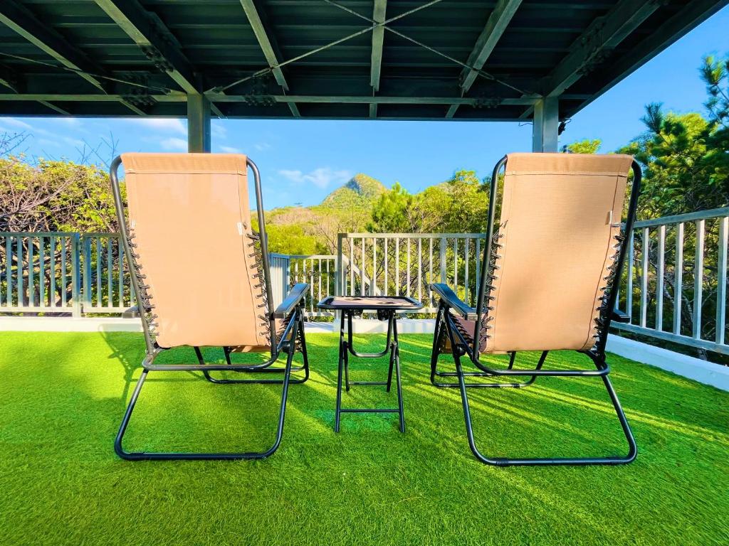 dwa krzesła i stół na trawniku w obiekcie Lodge Crea w mieście Ujimi