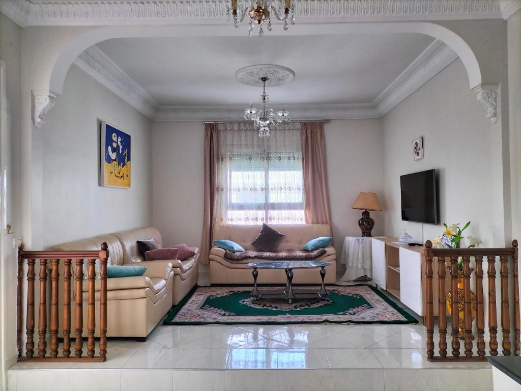 - un salon avec un canapé et une table dans l'établissement Villa Pierrette Casablanca, à Casablanca
