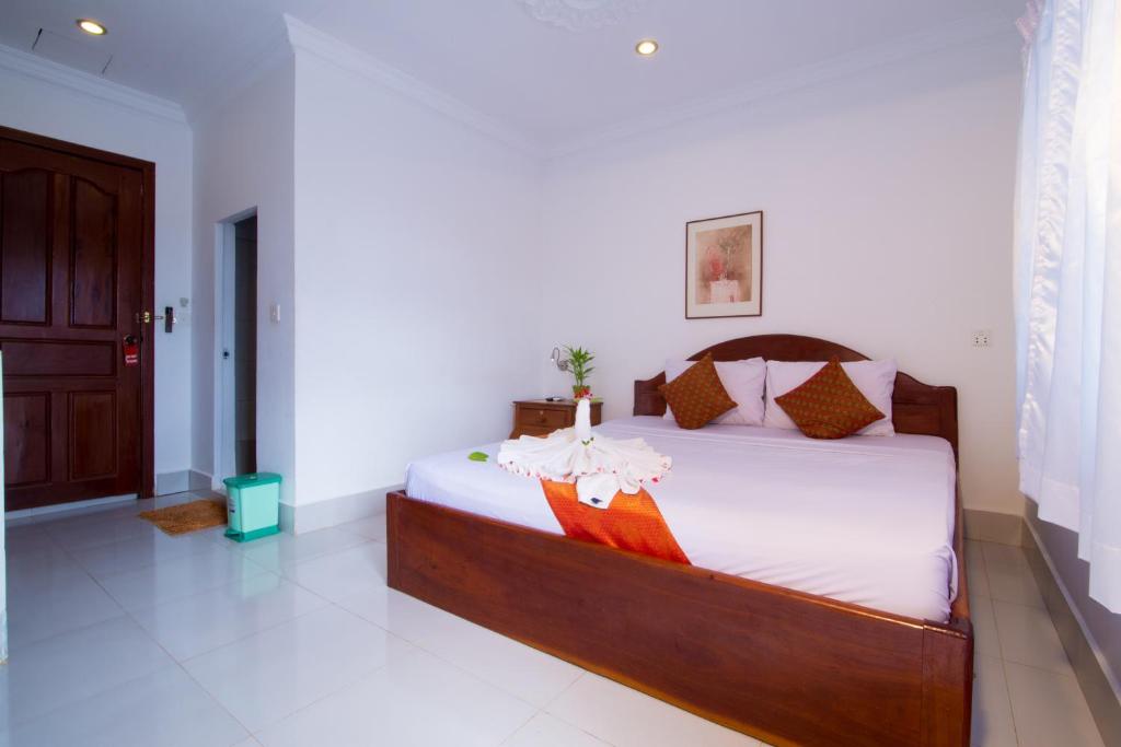 a bedroom with a large bed in a room at Blossoming Romduol Boutique in Siem Reap