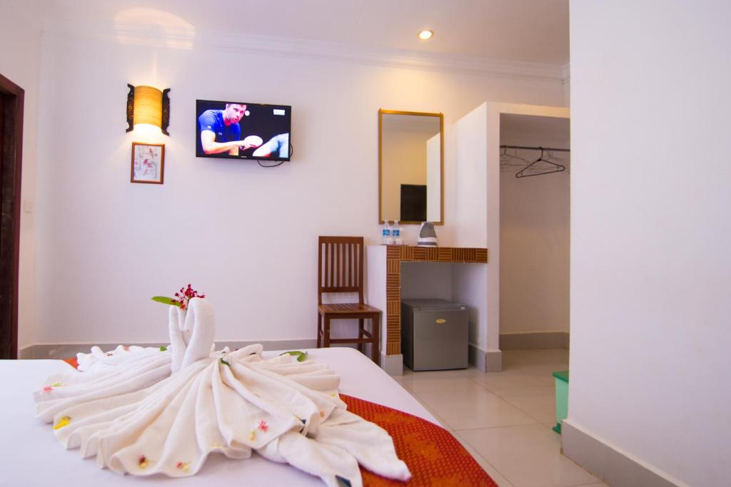 a room with a bed with a swan on it at Blossoming Romduol Boutique in Siem Reap