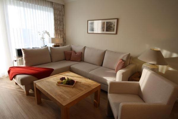 ein Wohnzimmer mit einem Sofa und einem Couchtisch in der Unterkunft Norderhoog Whg. 71 / 3.OG / W Wohnung 71 in Westerland