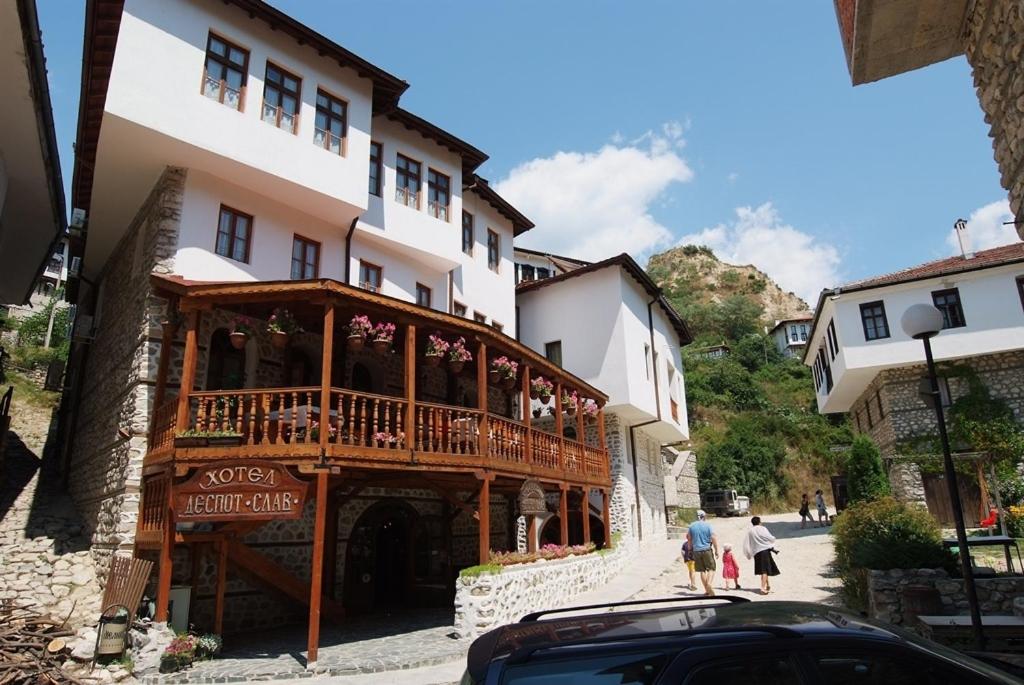 a building with a balcony on the side of a street at Despot Slav Hotel & Restaurant in Melnik