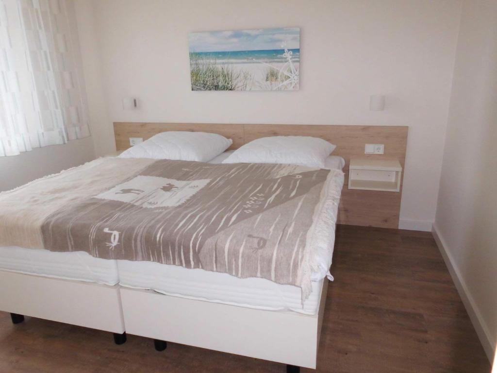 ein Schlafzimmer mit einem Bett mit einer Decke darauf in der Unterkunft Ferienwohnung ADL/1 1 in Sankt Peter-Ording