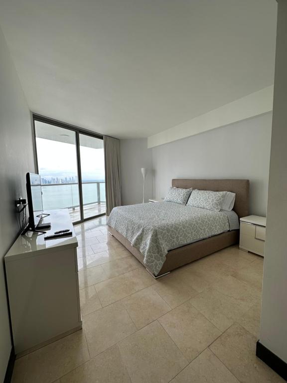 um quarto branco com uma cama e uma janela em Apartamento 5 estrellas, vista al mar na Cidade do Panamá