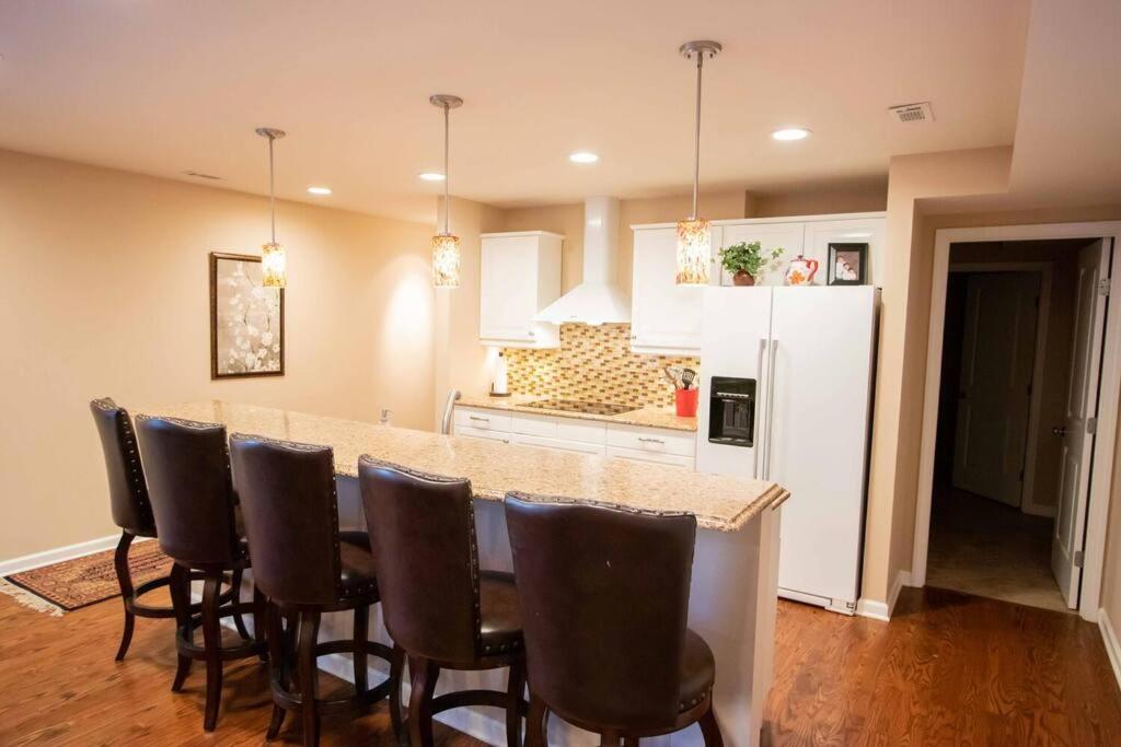 a kitchen with a bar with chairs and a white refrigerator at Charming Apartment on Oak in Cookeville