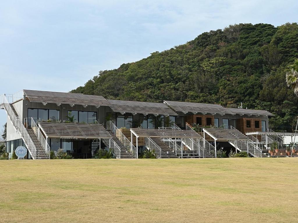 a building with bleachers in front of a mountain at Solasuna in Yukuhashi