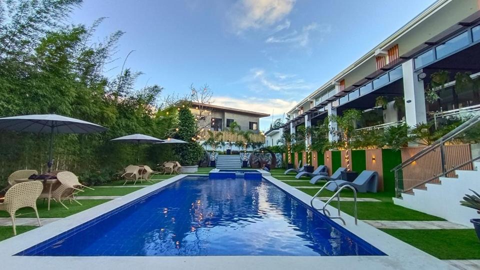 uma piscina com cadeiras e guarda-sóis ao lado de um edifício em Casa La Silvinas Hotel & Event Resort em Tagaytay