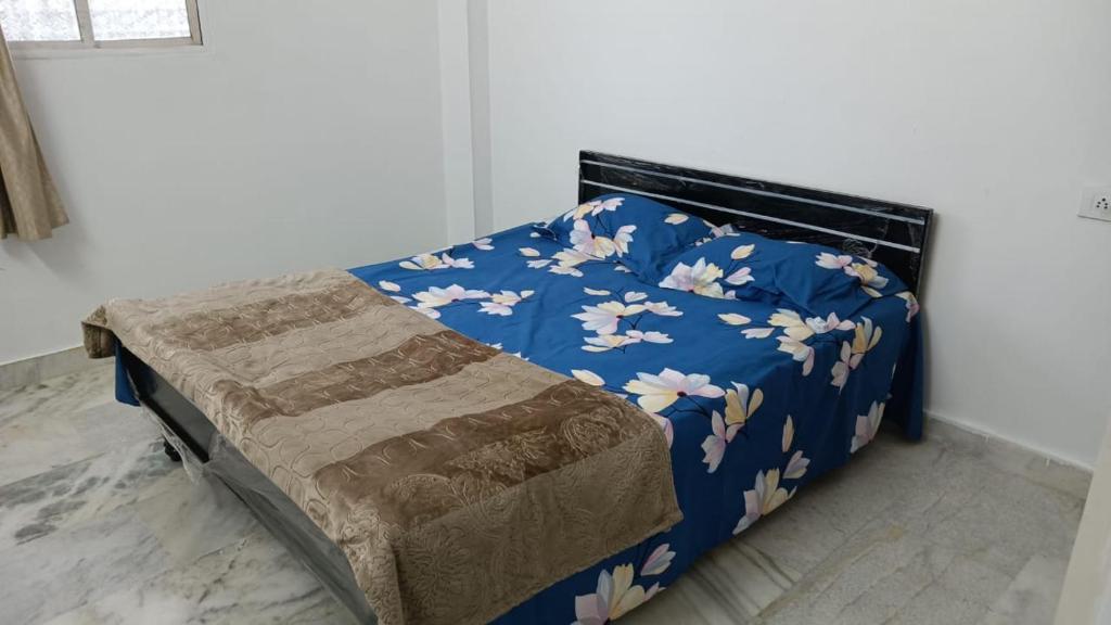 ein Schlafzimmer mit einem blauen Bett mit Blumen darauf in der Unterkunft Dumzy's Tombs View in Hyderabad