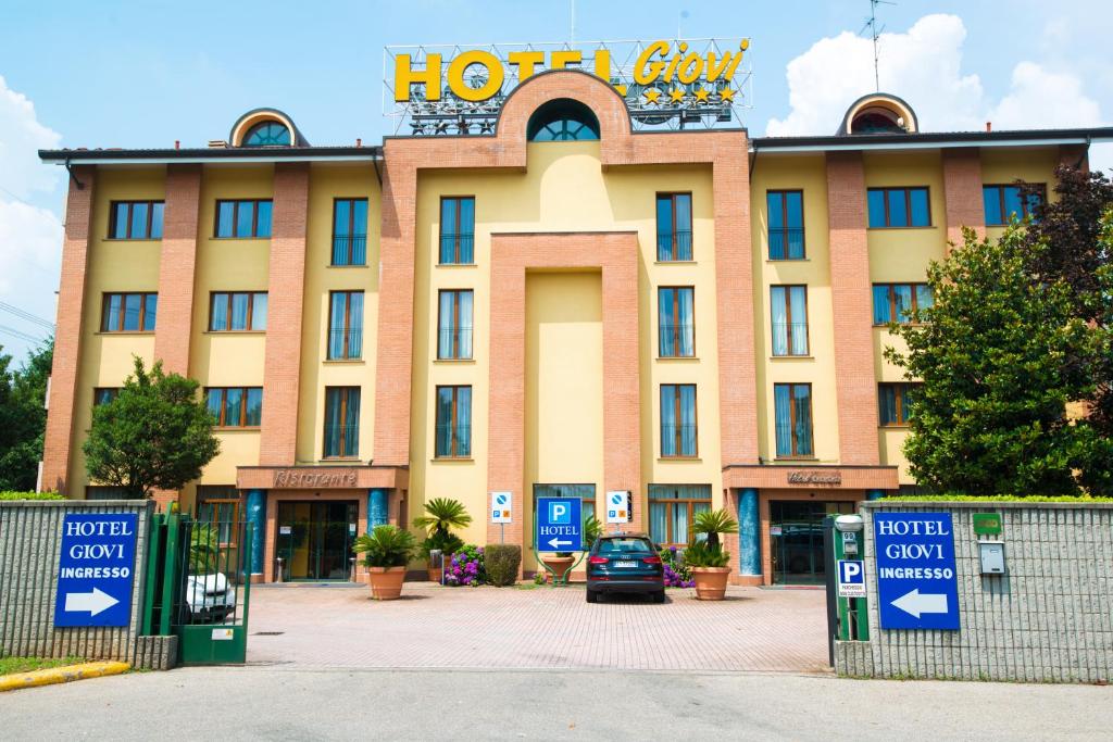 un edificio de hotel con un aparcamiento enfrente en As Hotel Dei Giovi, en Cesano Maderno