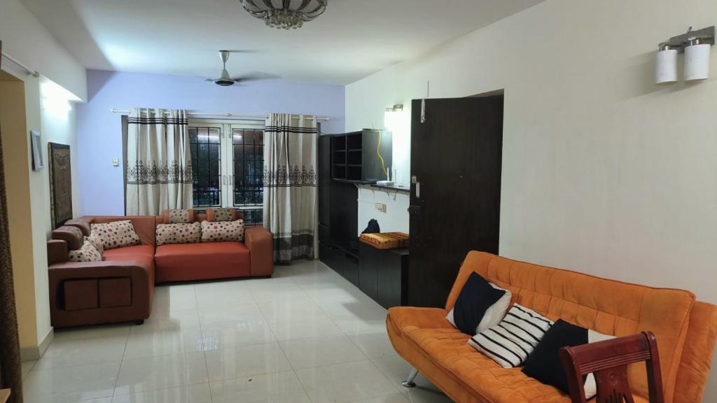 a living room with two couches and a tv at Royale Seaward Service Apartments in Chennai